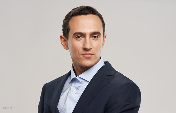 young male model facing sideways wearing an office shirt and suit