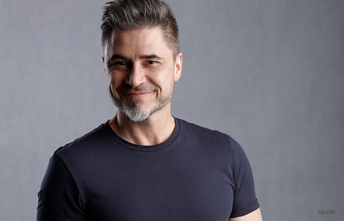 male model wearing a black shirt smiling for male facelift