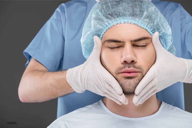 Man preparing for surgery with his surgeon's hands surrounding his face.