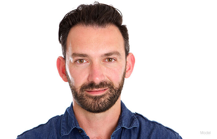 male mode facing forward with black short hair and blue polo shirt