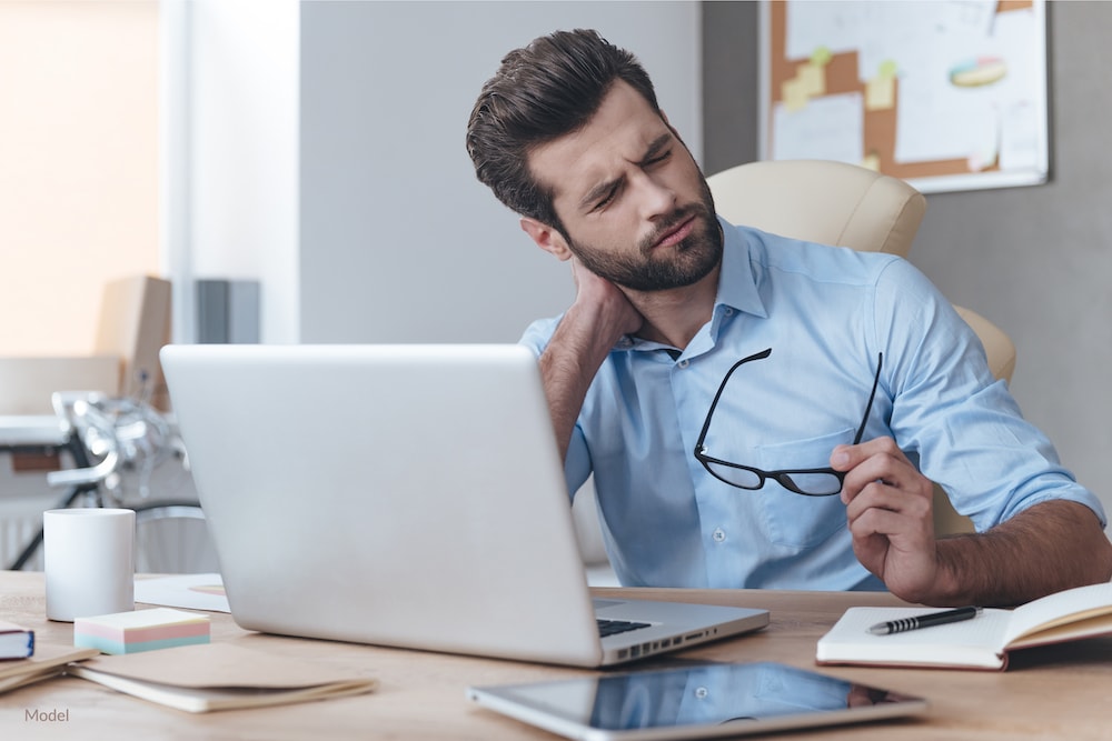 Man with tech neck straining neck in front of computer.