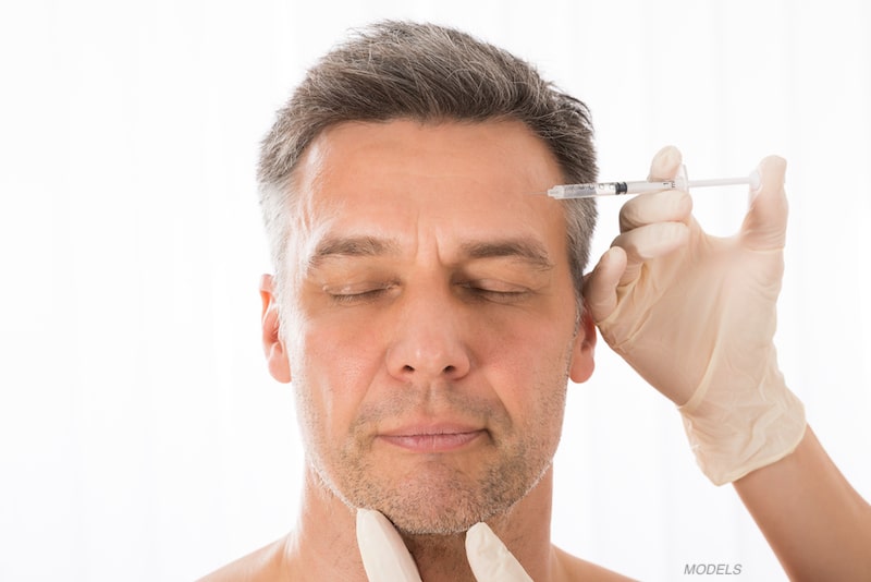 Man getting a BOTOX® Cosmetic injection into his forehead.